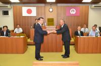 平成29年9月定例会の本会議上、町民の思いを「意見書」として鈴木町長に提出した岡崎議長の写真