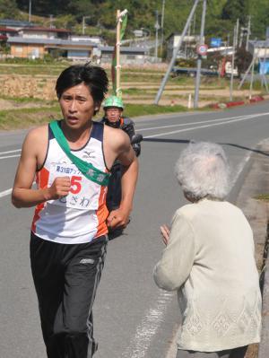 道で応援されて走っている選手の写真
