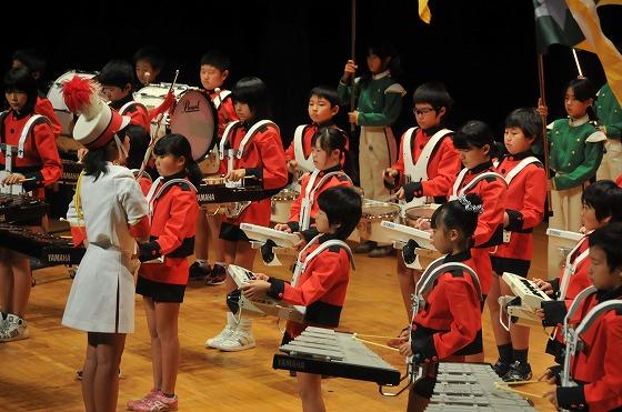 指揮に合わせ、息の合った演奏を見せる子供たちの写真