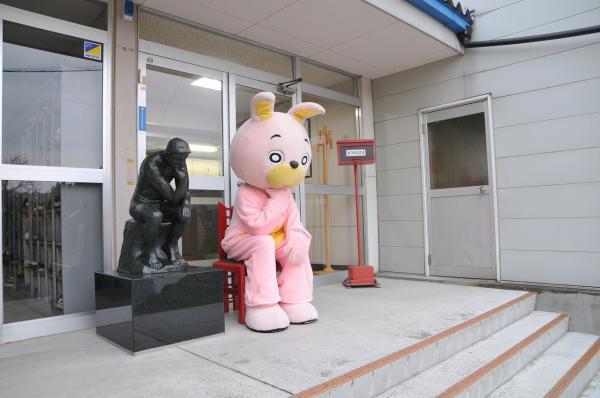 椅子に座って考える人と並んでいるウサヒの写真