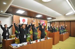 町議会の開会前に両手を上げて天を仰ぎ深呼吸する様子の写真