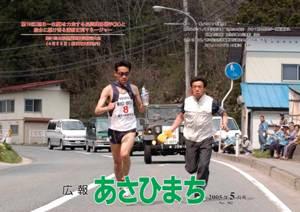 (写真)第19区(朝日~白鷹)を力走する長岡輝喜選手(左)と給水に駆け寄る清野正利マネージャー