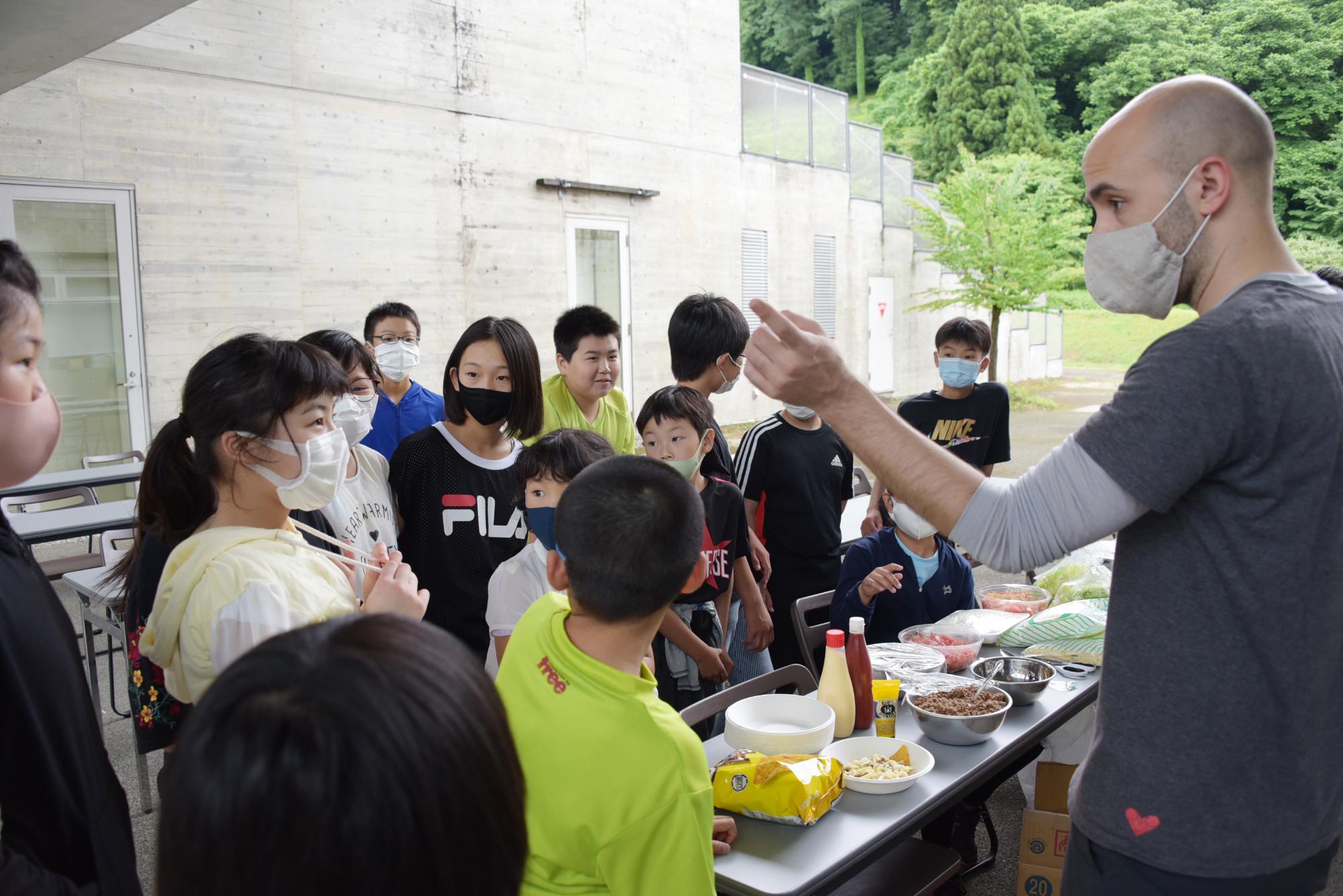 ナチョスの作り方をマーティ先生に教わる子どもたち