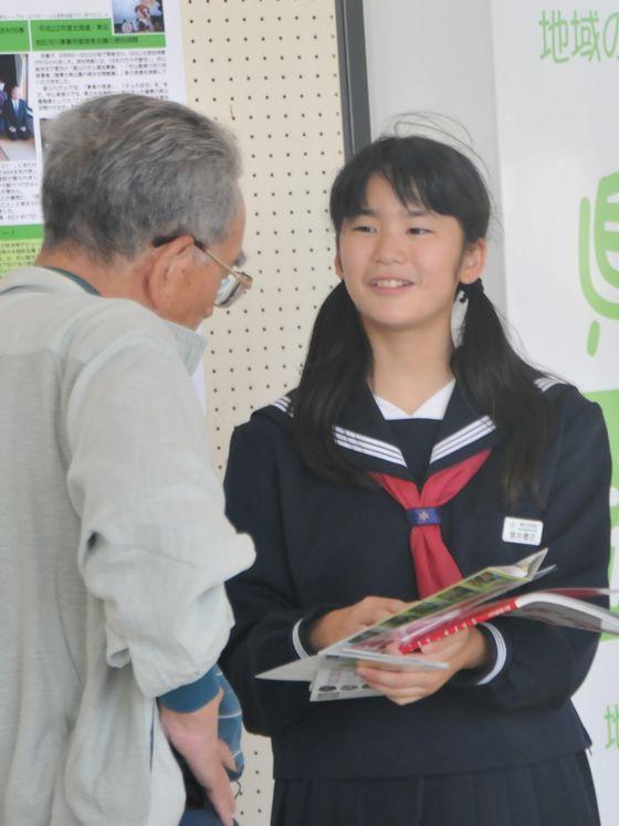 恥ずかしさを振り切って、道行く人に話しかける女子学生の写真