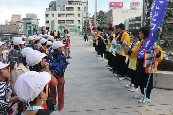 駅東口でのPR活動で遠足で訪れた小学生が珍しそうに足を止めている様子の写真