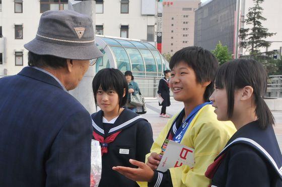 女子学生三人が一生懸命町をPR活動をしている様子の写真