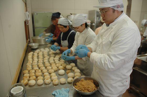 「東北地方太平洋沖地震」の被災者を支援するためにおにぎりを作る町産業創造推進機構のスタッフと、「中沢みらくる会」の皆さんの写真