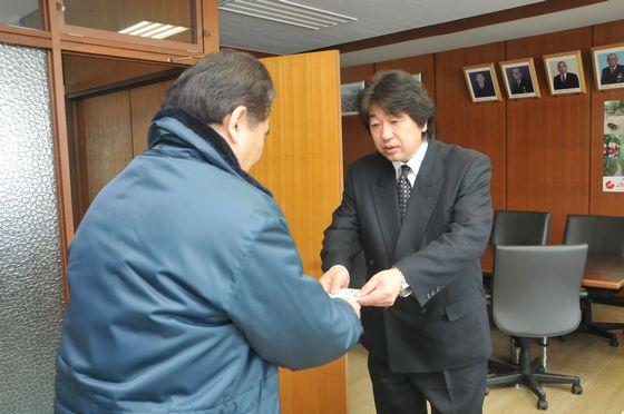 義援金を手渡す佐藤欣治大東建設株式会社社長と、受け取る鈴木町長の写真