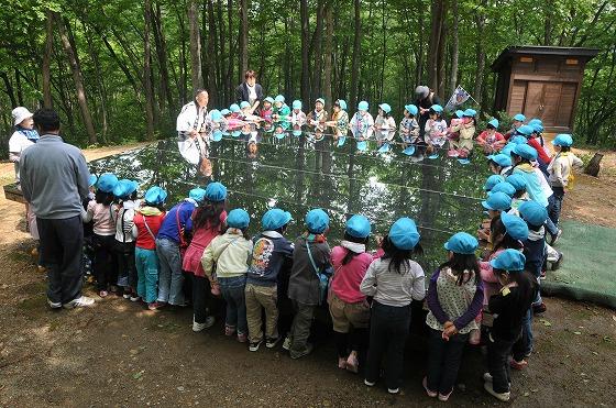 空気神社のステンレス床を取り囲んで空気神社の説明を聞く園児の写真1