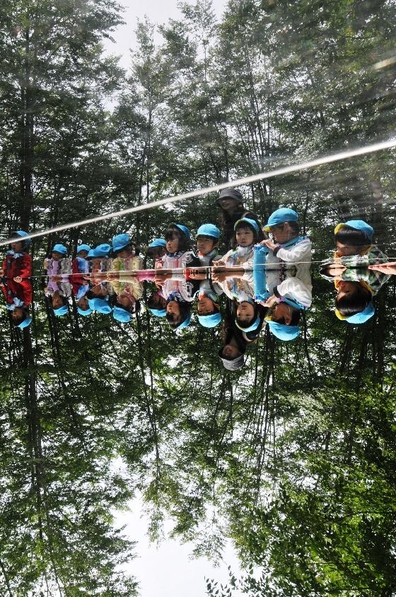 空気神社のステンレス床を取り囲んで空気神社の説明を聞く園児の写真4