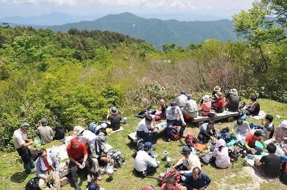 夏山開きの式典が終わり外で昼食を取る参加者の写真
