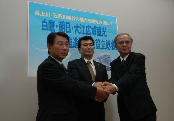 白鷹・朝日・大江の3町の各首長が互いに手を取り合っている様子の写真