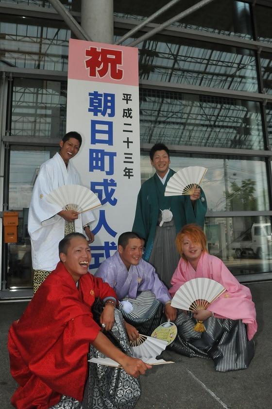 成人式の看板の前で記念撮影する新成人たちの写真
