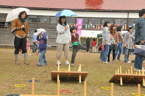 雨の中、親子で輪投げを楽しむ様子の写真