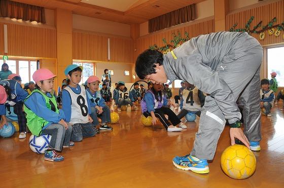 ボール遊びを園児に指導するコーチの写真