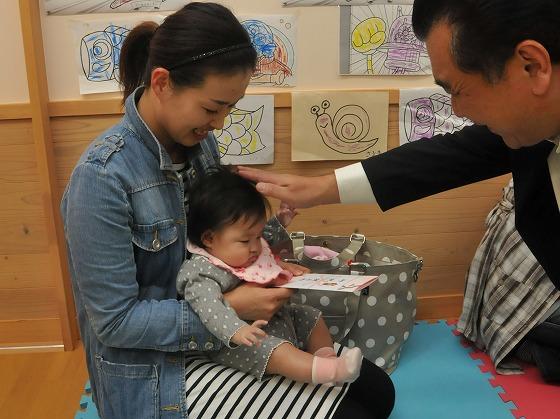 出産祝い品を受け取る親子の写真
