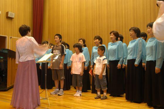 児童と一緒に歌うさくらの会のみなさんの写真