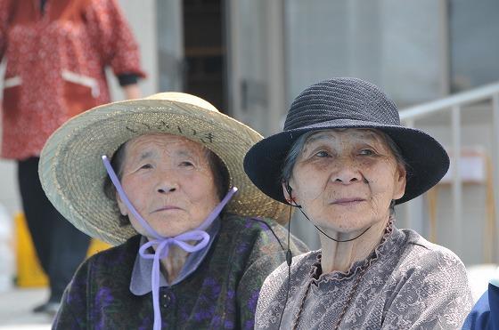 女性参加者が設置されるかかしを見守る様子の写真2