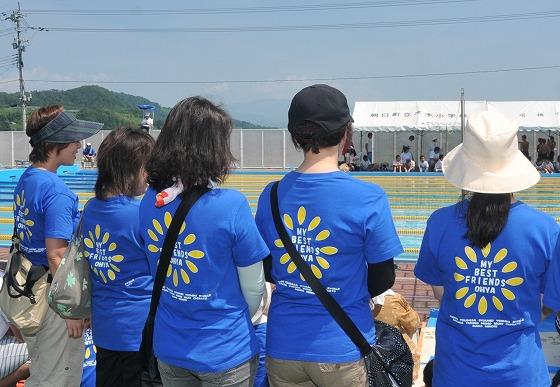 花びらのような模様が背にあるTシャツを大谷小学校の保護者がおそろいで着ている様子の写真