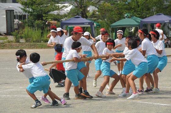 長い竹の棒を引っ張り合う競技に参加中の男女の生徒たちの写真