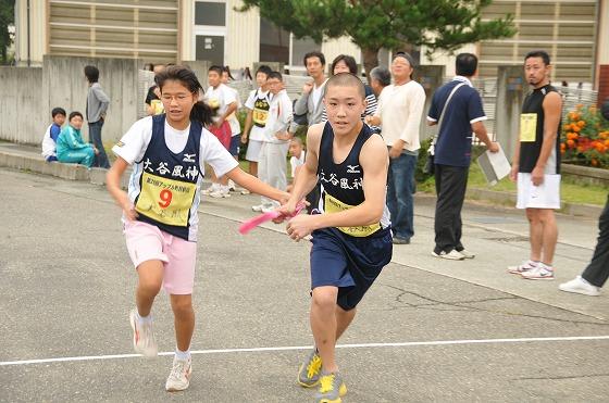 朝日町ワイン前で選手たちがタスキリレーをしている写真