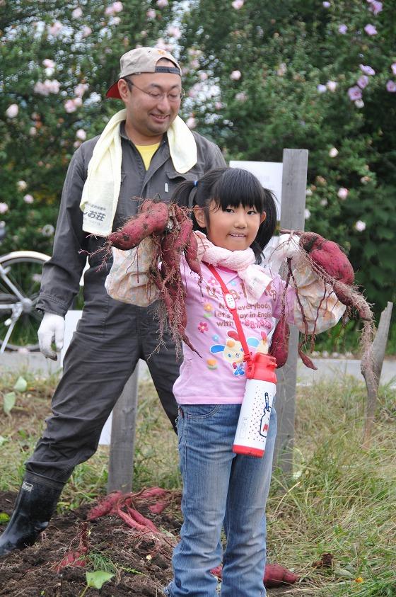 子どもがサツマイモを持っている写真