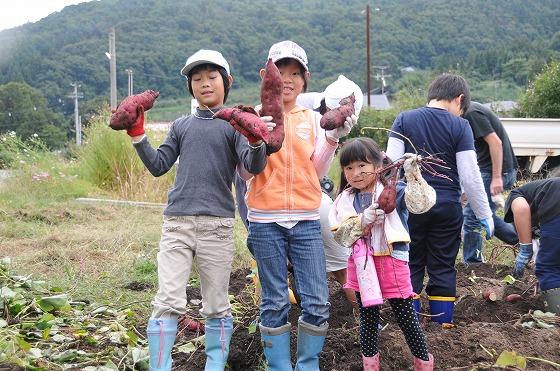 子どもたちがサツマイモを持っている写真