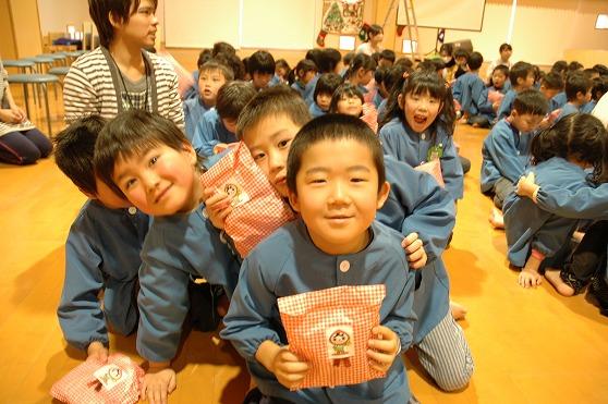 プレゼントを貰って笑顔を溢す園児達の写真