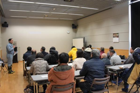 会議室に集まり、席に着く人々の写真