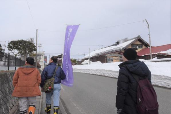 案内人を先頭に、歩いて移動している写真