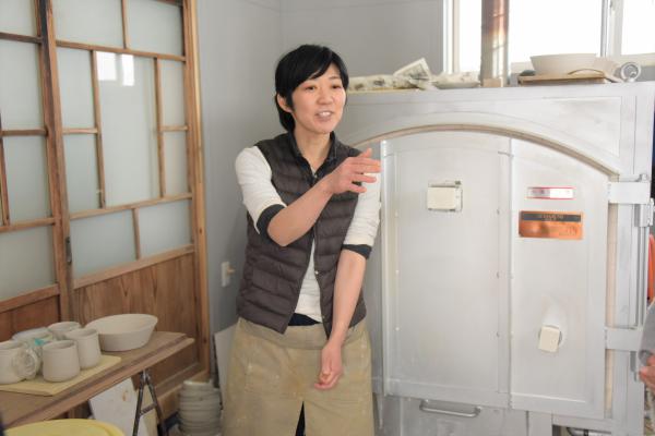 ガス窯の前でお話する長岡さんの写真