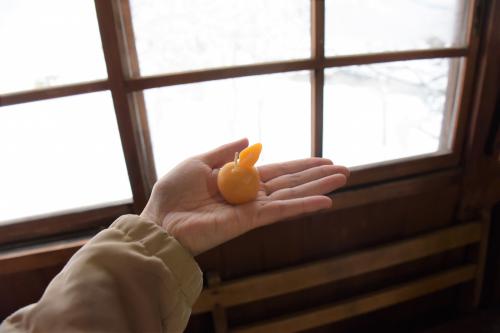 りんごの形の蜜ろうキャンドルを持った手のひら