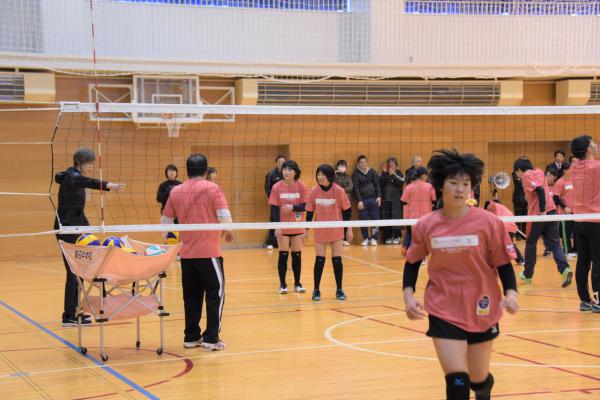 ネット際の動きについてレクチャーを受けている女子バレー部の生徒たち