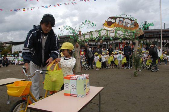 「親子競技 地球にやさしいお買い物」でエコマークの付いた商品を選んで購入する場面の親子の写真
