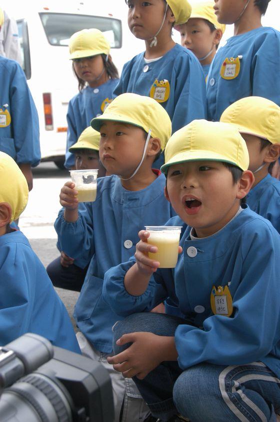 りんごジュースを美味しそうに飲む、さゆり保育園の園児たちの写真