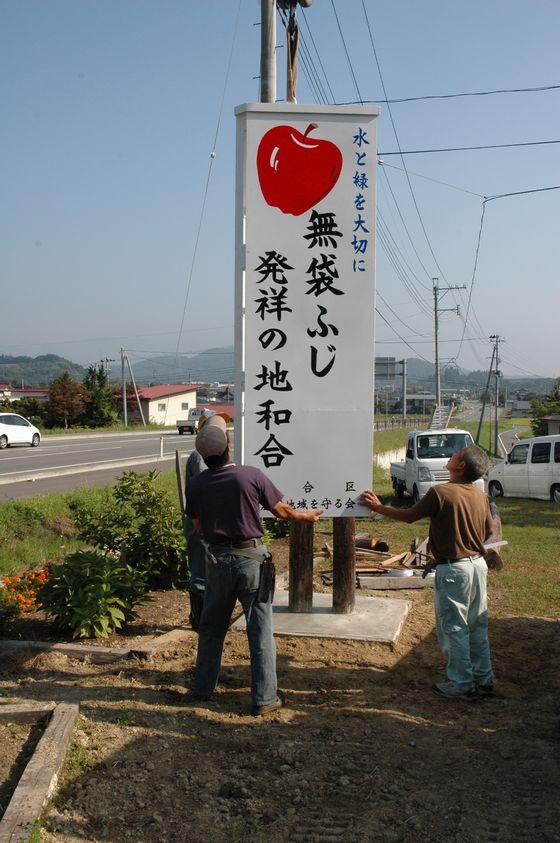 和合を象徴する見事な看板を眺める住民たちの写真