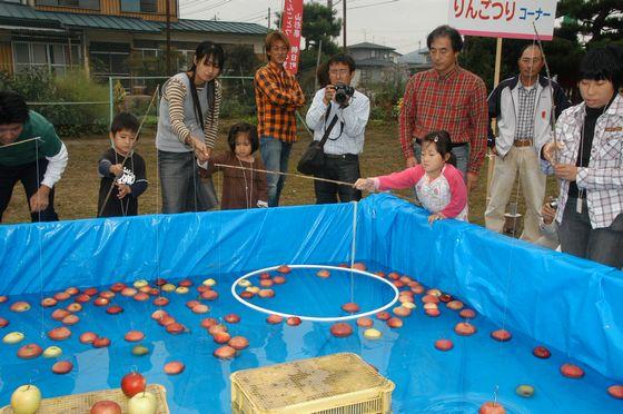 和合りんごまつりでりんご釣りを楽しんでいる親子の写真
