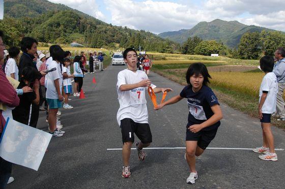 道で宮宿Aチームがタスキリレーしている写真