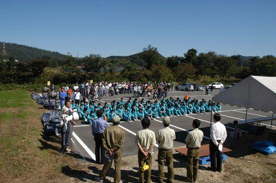 ワイン城(朝日町ワイン)内園地でぶどうの収穫の方法を説明されている朝日中3年生たちの写真