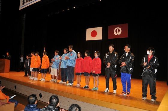 閉会式でジャンパーをそろえたチームが登壇してデザインを紹介している写真