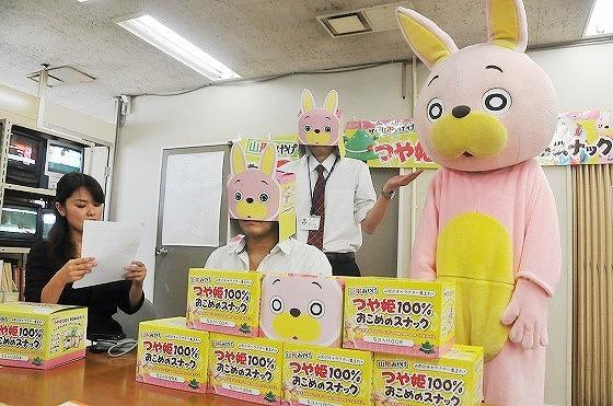 つや姫スナックの箱を被る町職員達の写真