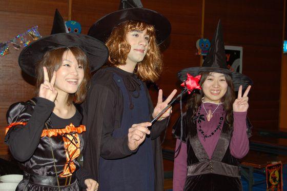 魔女の仮装をした女性たちがピースして記念撮影する様子の写真