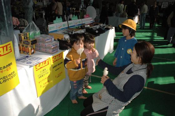 わたあめを食べて喜ぶ子供たちの写真