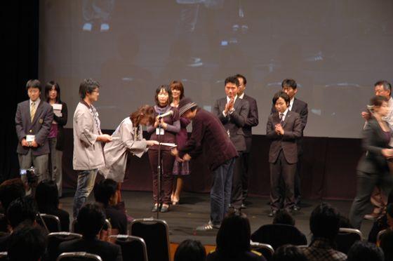 「やまがたふるさとCM大賞」の審査会で、審査員より表彰を受けている様子の写真