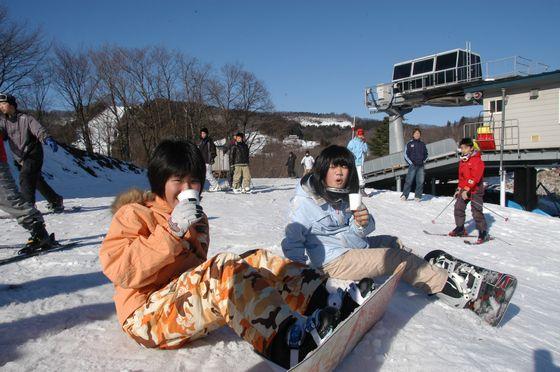 甘酒を飲む二人の子どもの写真