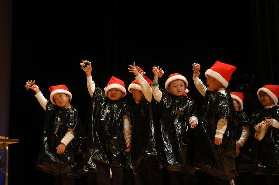 ゴミ袋を使った衣装を纏い演技する園児達の写真