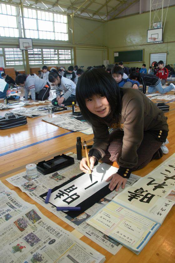 宮宿小書き初め大会で「晴れた空」を書こうとしている児童がこちらを見ている写真