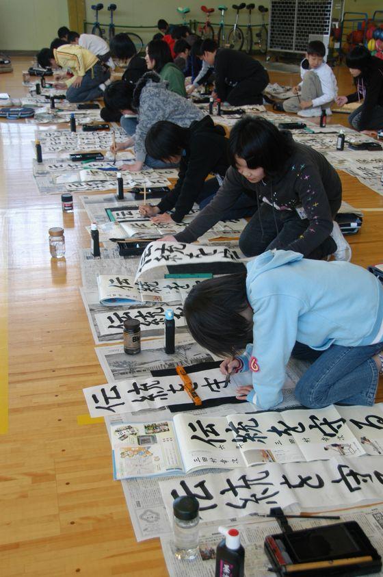 宮宿小書き初め大会で「伝統を守る」を書いている6年生児童たちの写真