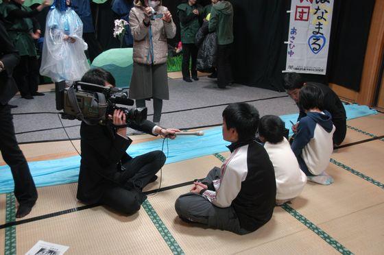 3人の児童が報道機関の方々より取材を受けている写真