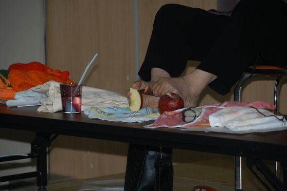 足でりんごの皮むきをする写真